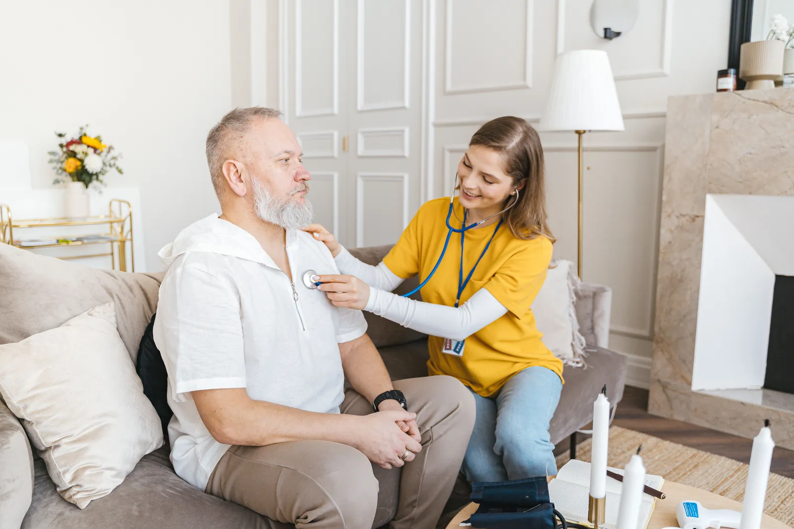 A nurse carrying out a home check-up on an older man in his own living room